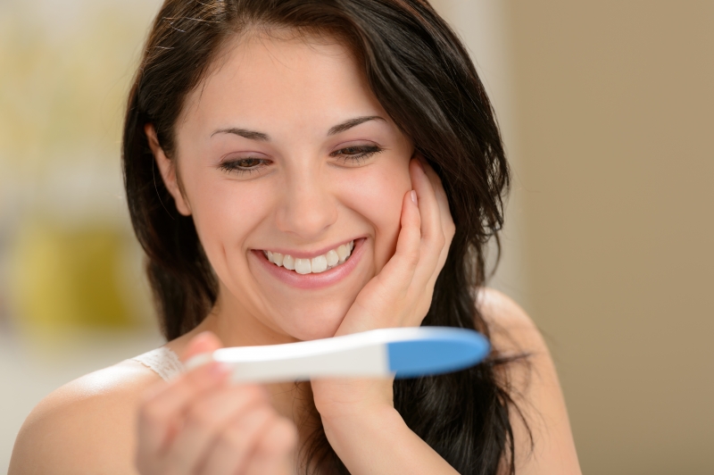 5585782-delighted-woman-holding-pregnancy-test